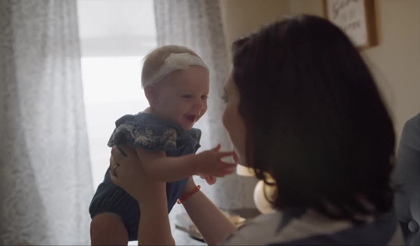 A woman holds a smiling baby