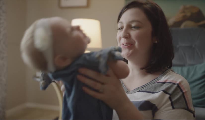 Woman smiles as she plays with a baby