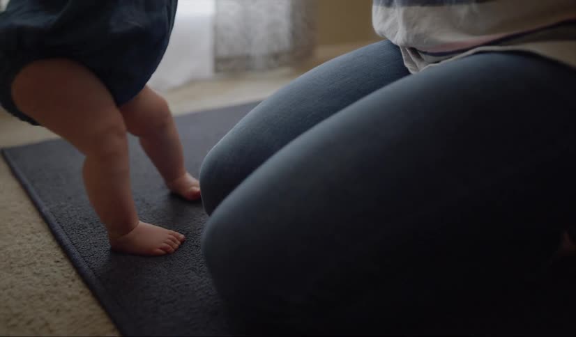 Adult holding a baby while it wiggles its legs