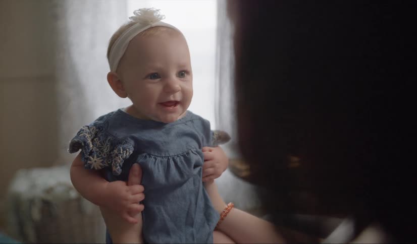 A woman holds a smiling baby