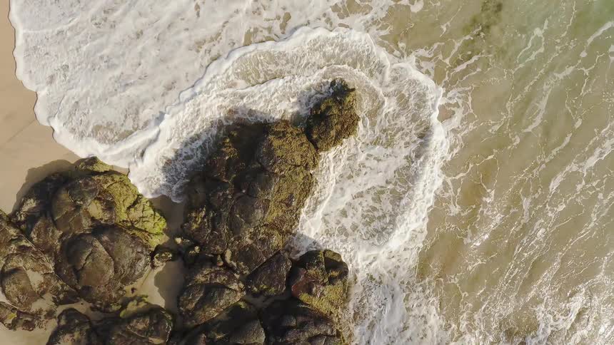 The waves slowly reach the sand of the shore