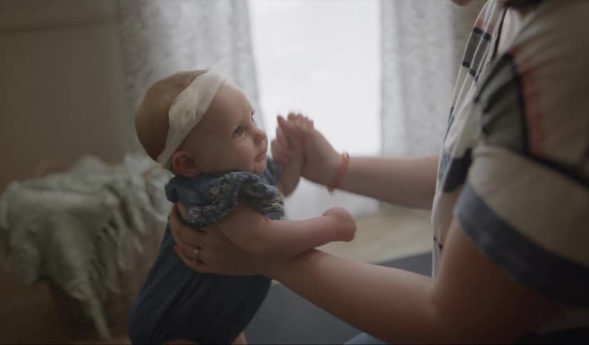 Woman plays with a baby while kneeling on the floor