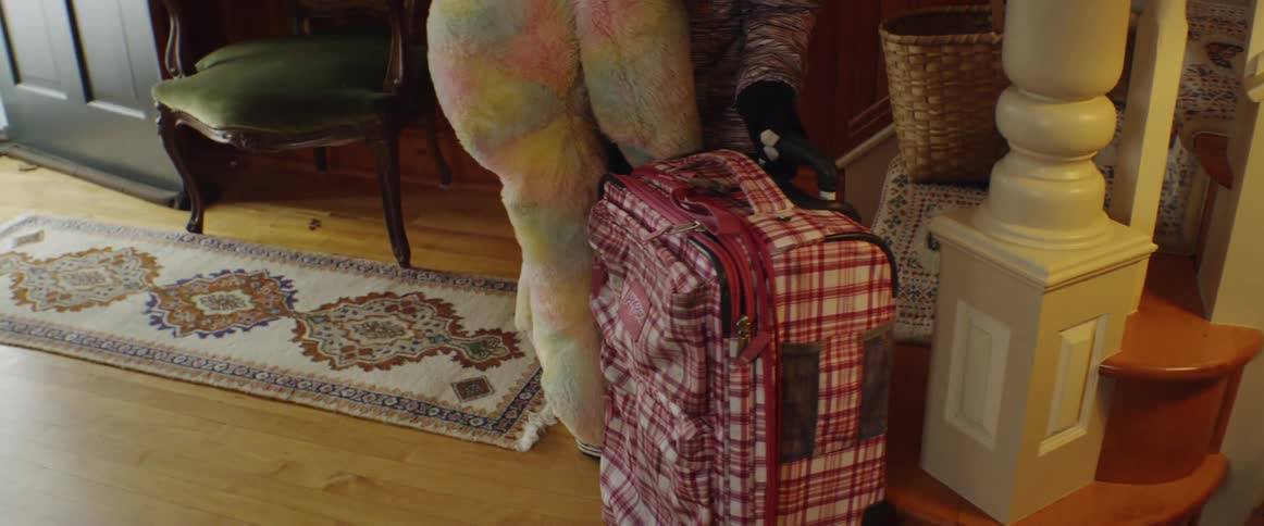Girl picks up giant teddy bear, grabs suitcase and heads out the door