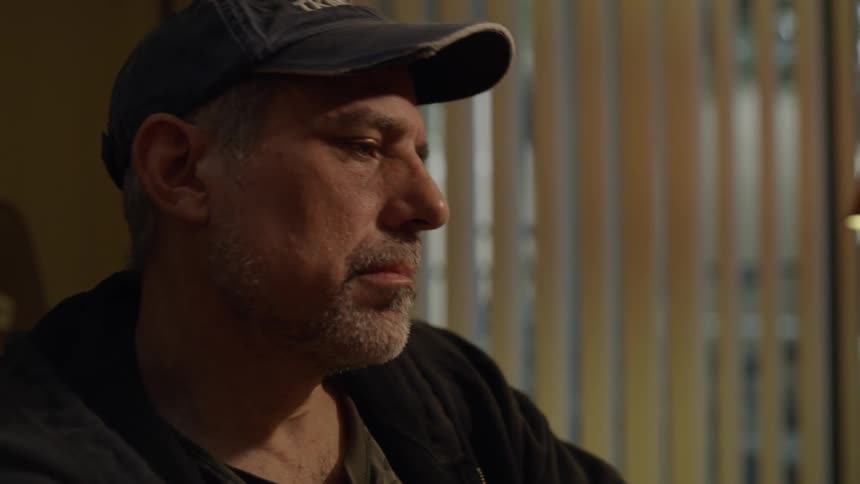 Man looks sad while sitting near a lamp at home