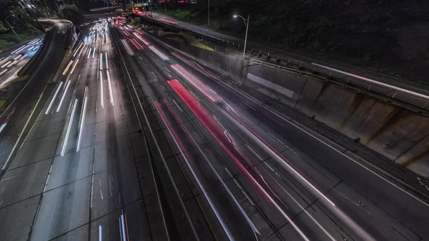 Cars drive on a highway at night