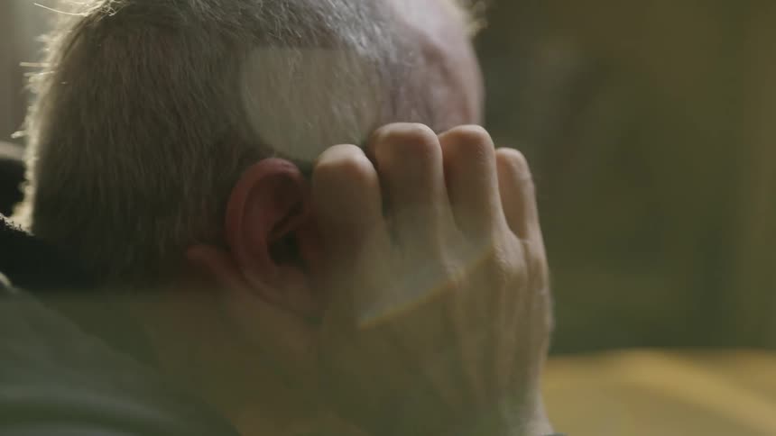 A man scratches the side of his head