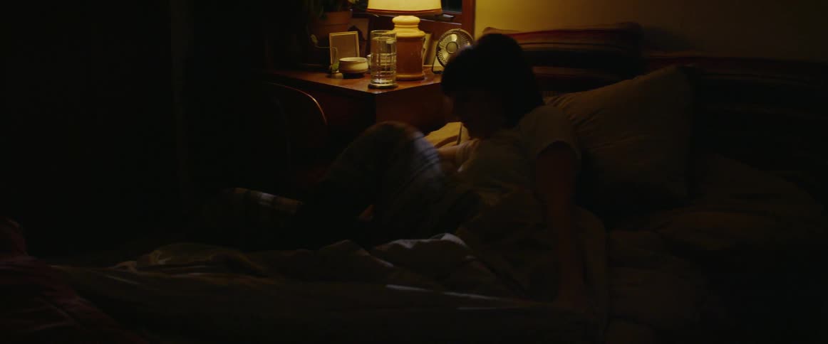 A woman gets out of bed in the dark room