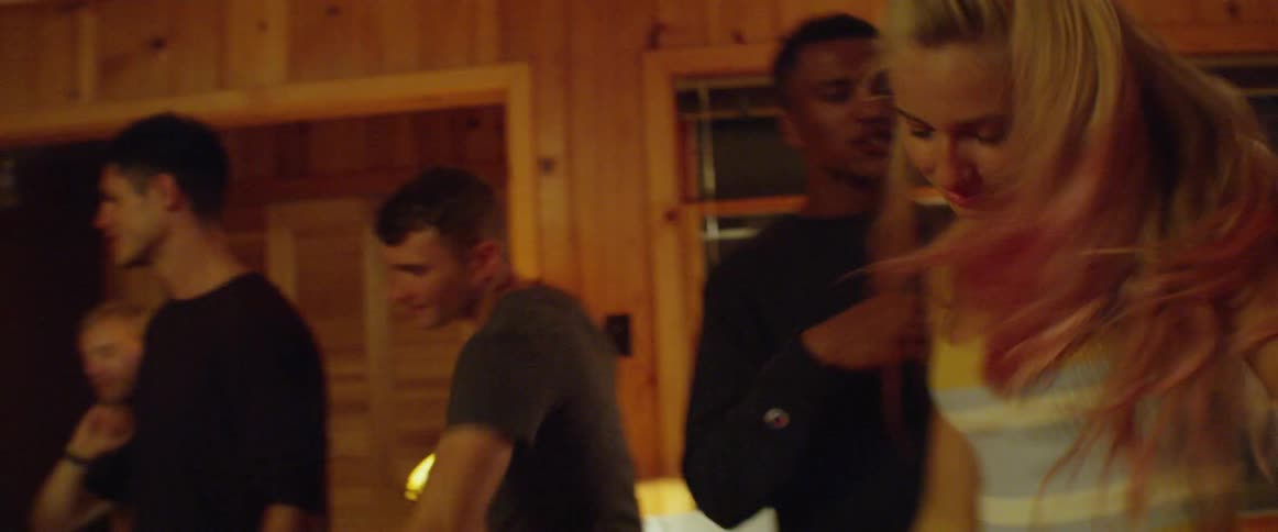 Group of people dance in a wood paneled room