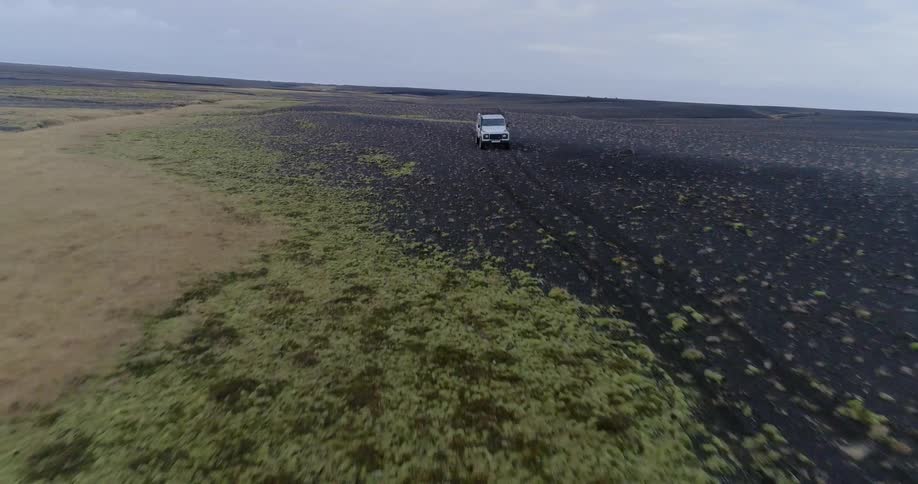 A vehicle drives across a dirt field