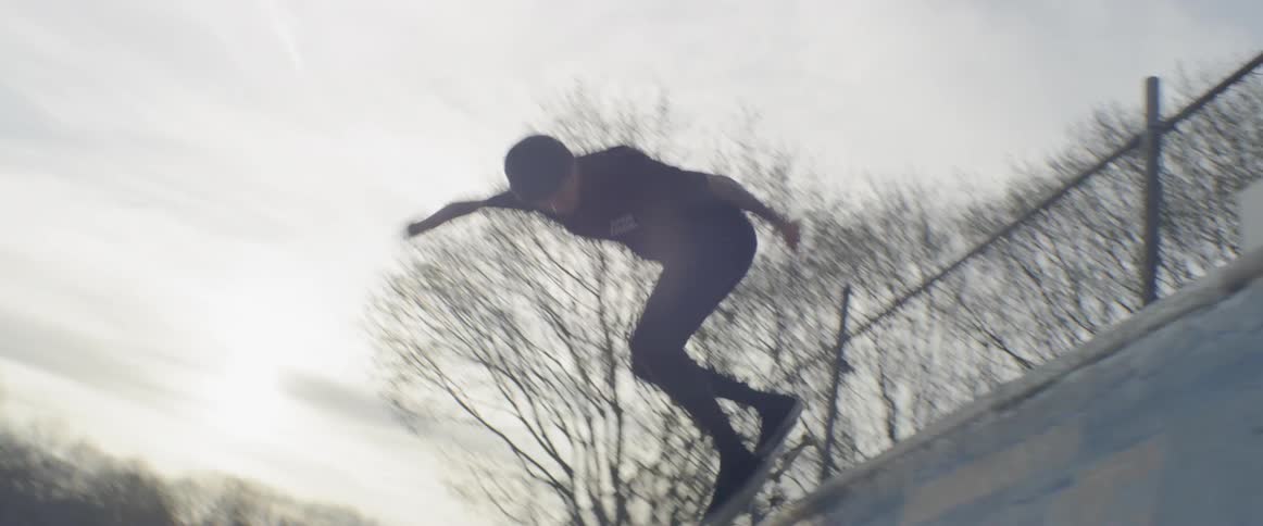 A skateboarder rides up a halfpipe