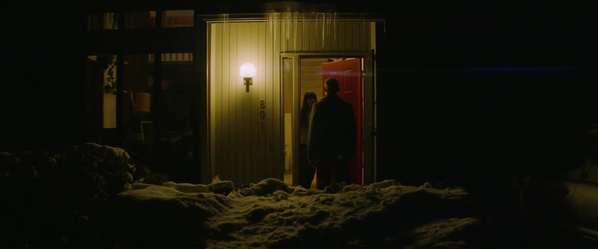 A man is reuniting with a woman at home at night