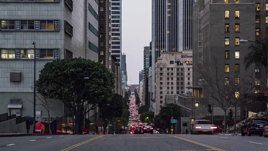 The busy city road has many cars and people traveling