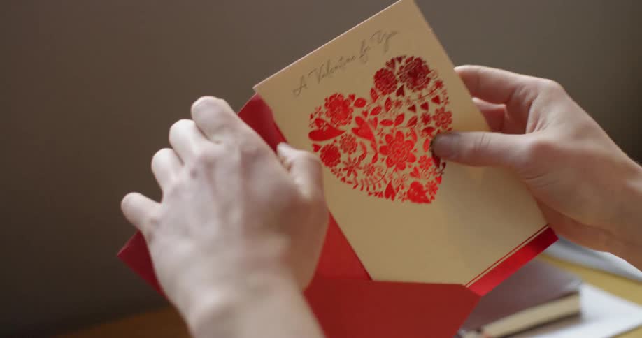 Person puts a greeting card in a red envelope