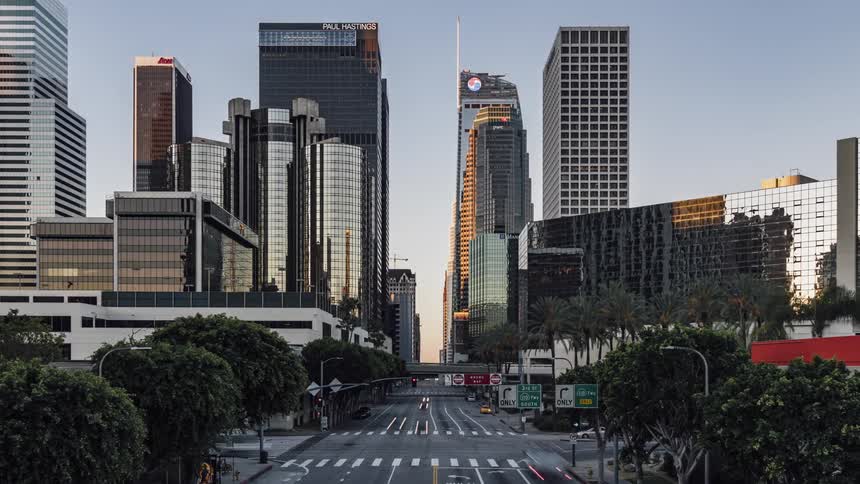 Cars travel down the long road in the city as day breaks
