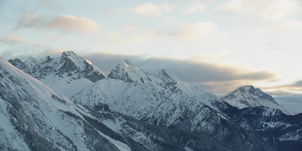 Snow covered mountains sit under a blue sky