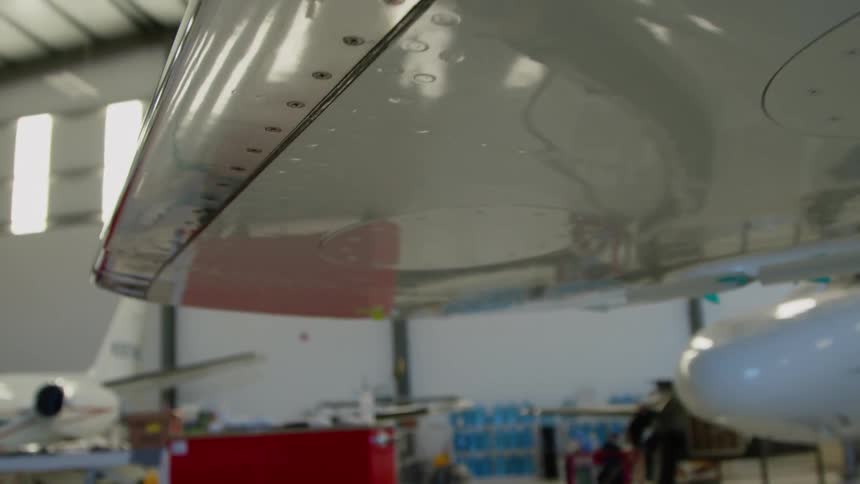Under wing of a plane in a hangar with other planes
