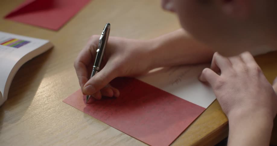 Person writing on a greeting card