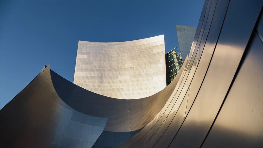 The sun rises over a large building