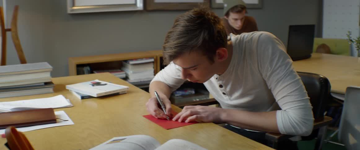 People are working in the office writing on postcards