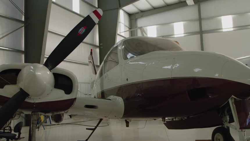 Airplanes in a large airplane garage with the sun shining in