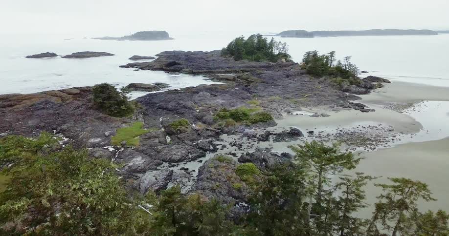 Trees and rocks sit surrounded by a lake
