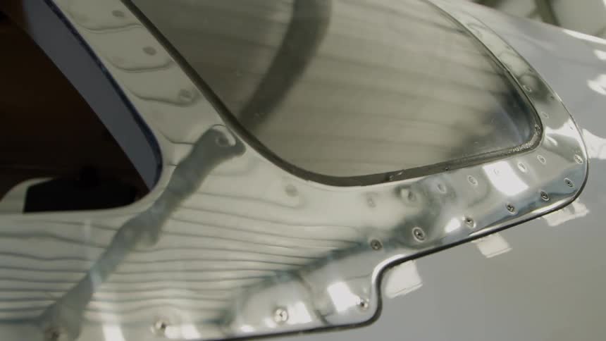 Shiny metal siding on airplane in hanger