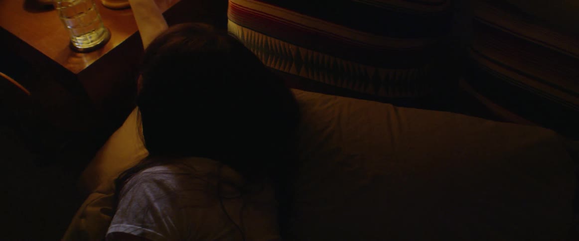 A woman turns off a bedroom lamp