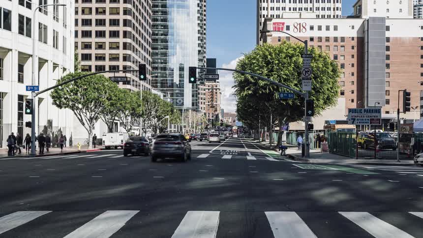 The busy intersection has many people crossing the street