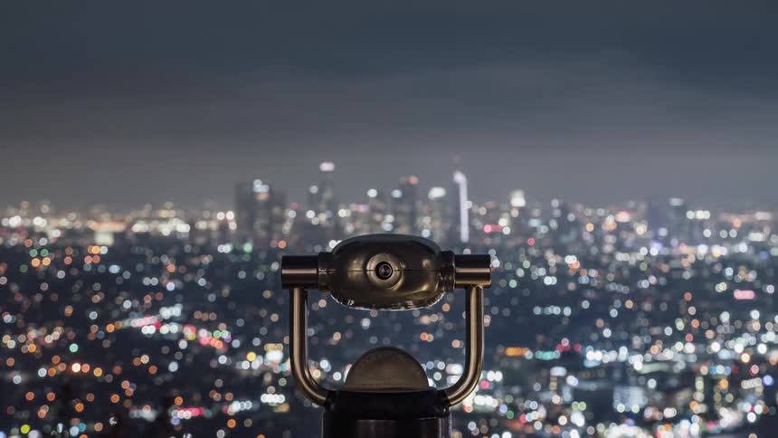People looking through binoculars out at a city