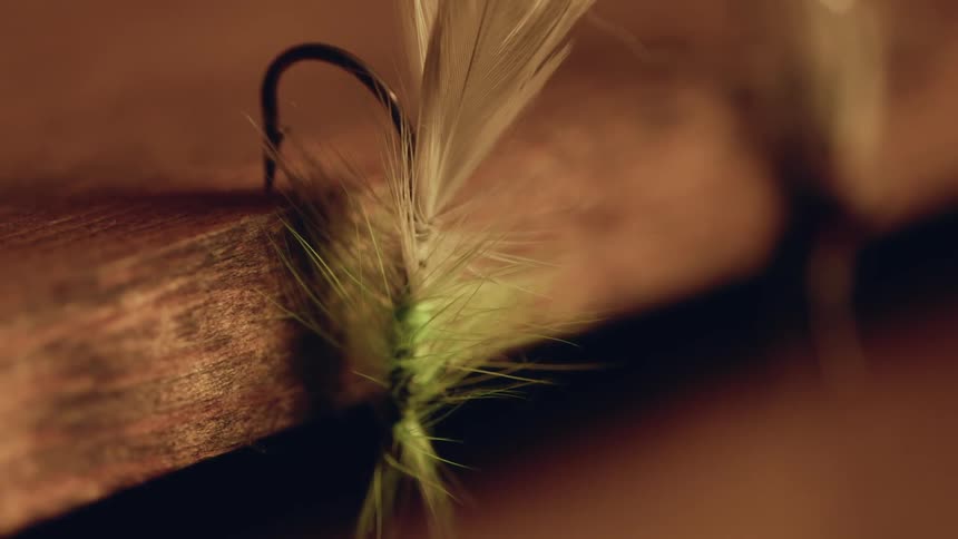Fishing hooks are hanging from the wooden shelf