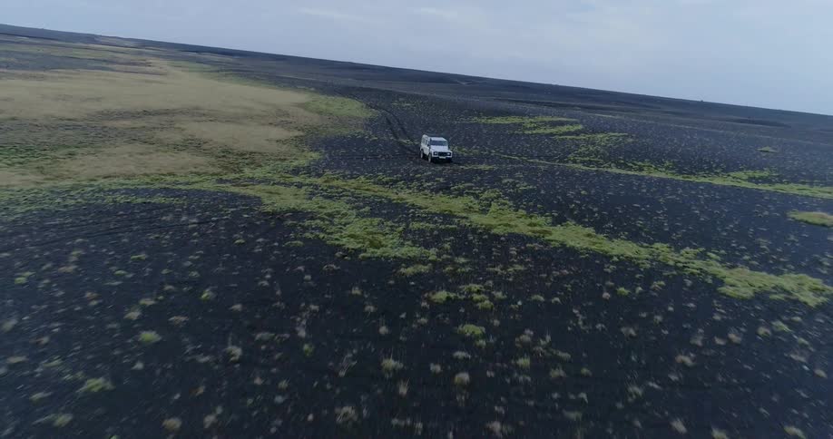 An suv creates tracks as it travels across dirt and sand