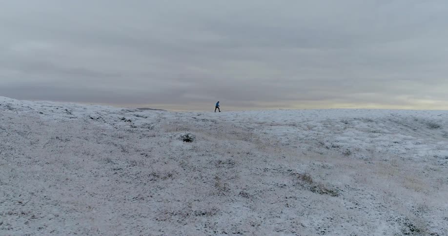 A person is hiking on the snowy hill ahead