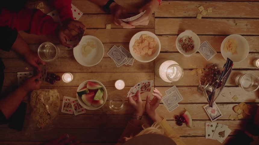A group of people play a card game together