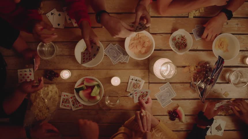 A group of people play a card game together