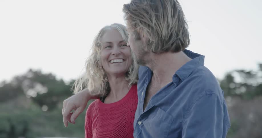 A man and woman hug and smile