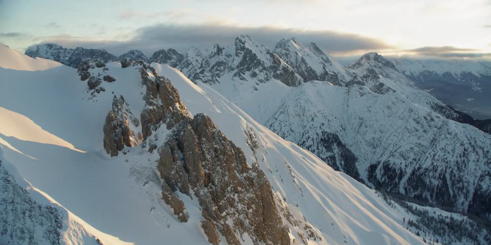 The mountains are tall and covered with heavy snow