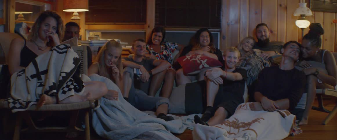 Group of teenagers sit together in a room at night