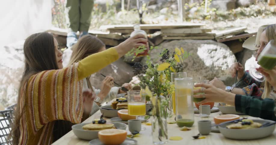 Men and women sit outside eating at a table