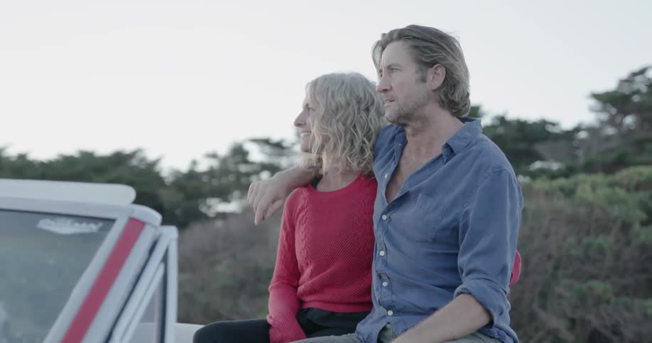 A man and woman sit together on a car