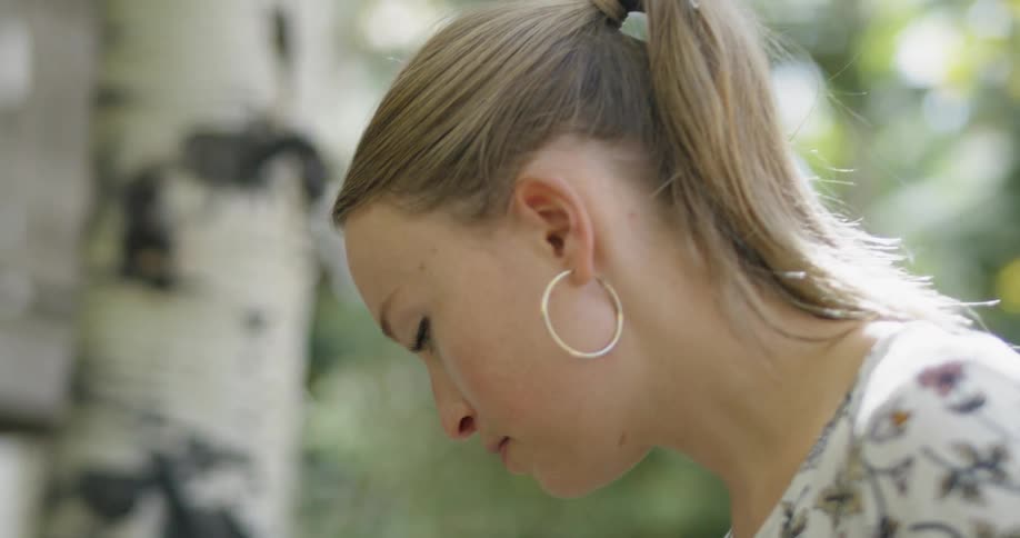 Woman wearing hooped earrings works intently