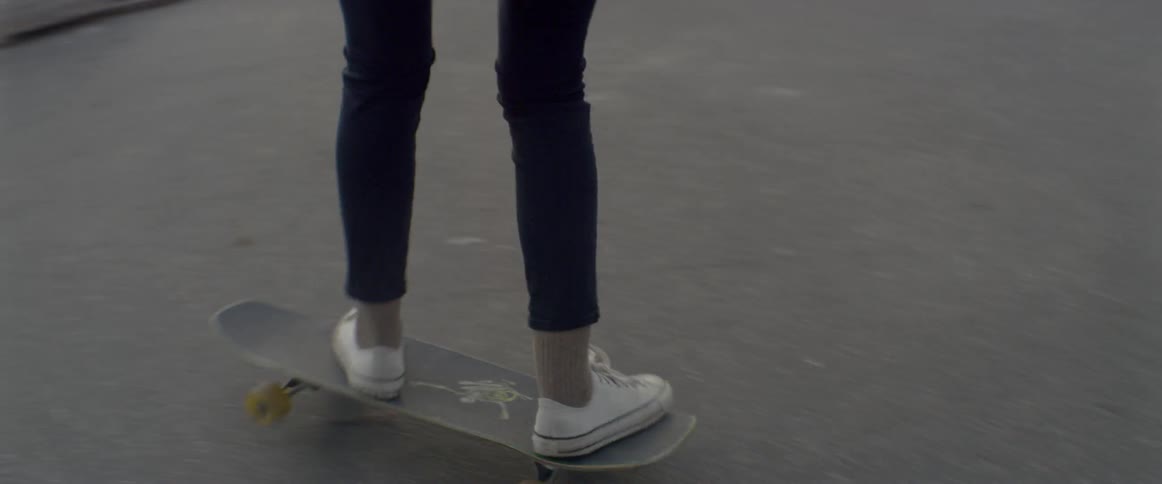 A girl rides a skateboard in a skate park