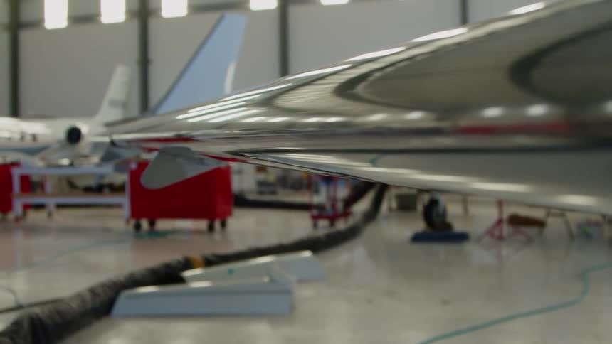 Airplanes in a large airplane garage with the sun shining in