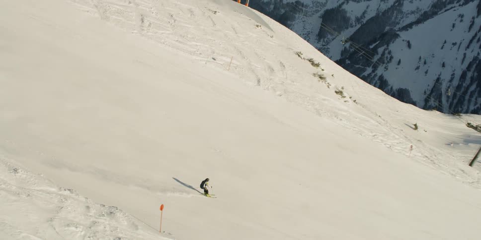 A skier glides down a snowy mountainside