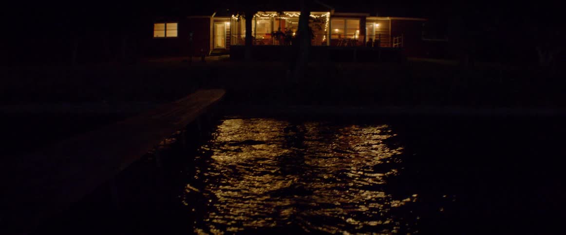 Lights from a cabin shine on the lake surface