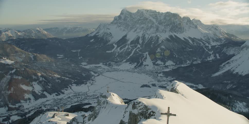 Cross statue on top of snow covered mountain