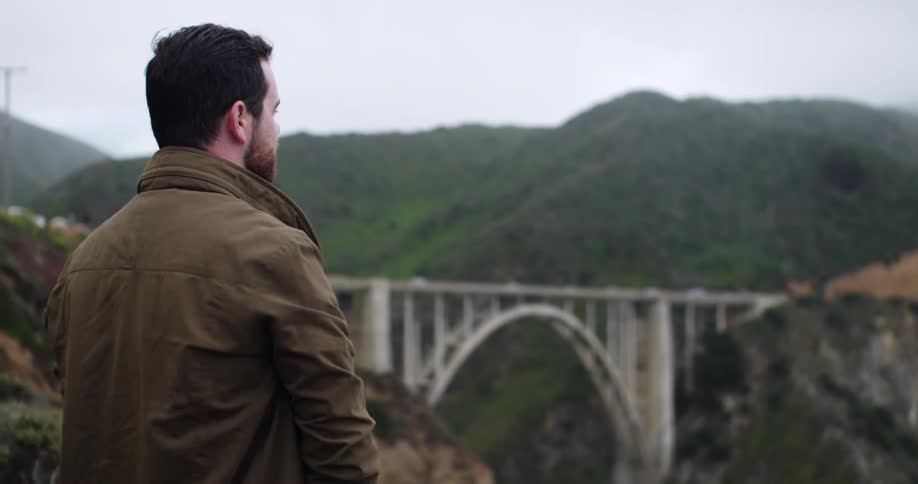 Man taking photos of a cliff on a foggy day