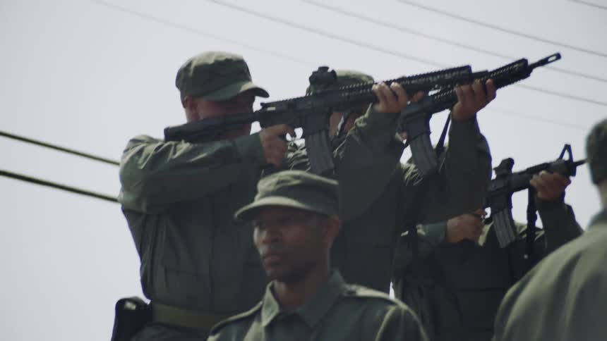 The soldiers on the platform point their rifles forward