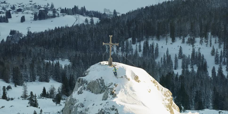 Cross on top of a snowy mountain on a cloudy day