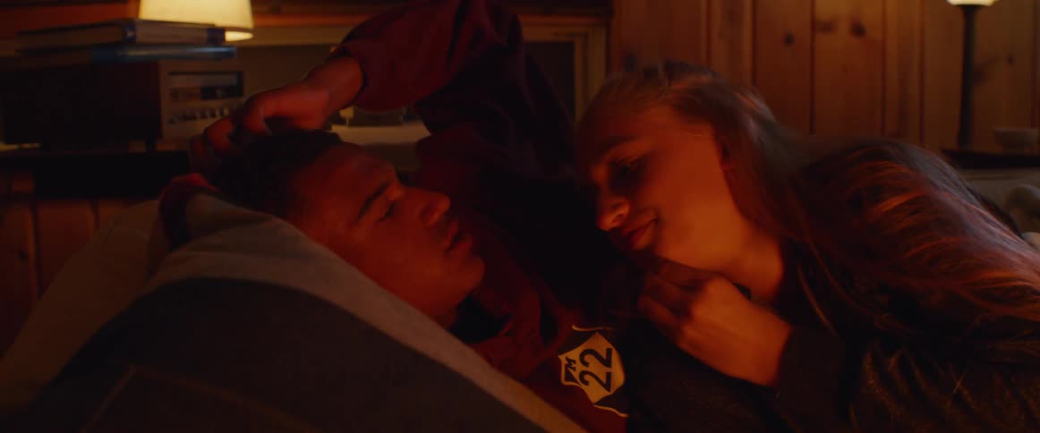 Man and woman cuddle on a couch