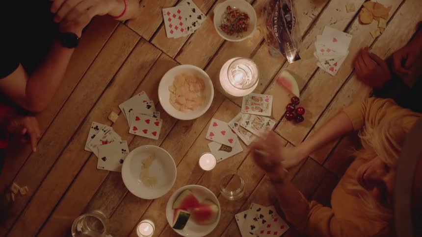 Group of people are playing card game at table